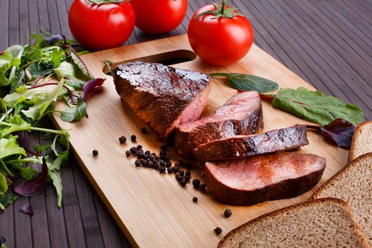 Close-up of Medium Rare Roast Beef with Fresh Herbs and Vegetables