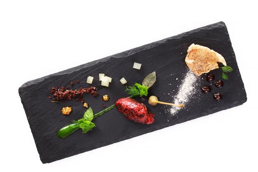 Molecular modern cuisine. Chips Pigskin with tartare or carpaccio of beef. Stock image. Isolated on white.