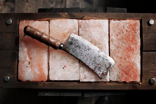 Vintage Meat cleaver on Himalayan pink salt. Salt plates. Bars of salt for cooking. Kitchen knife axe- Stock image