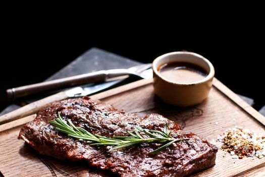 Beef steak. Piece of Grilled BBQ beef marinated in spices and herbs on a rustic wooden board over rough wooden desk with a copy space. Top view