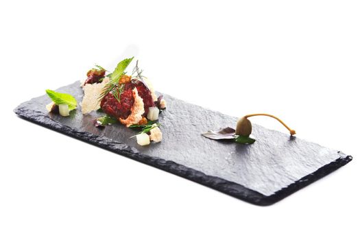 Molecular modern cuisine. Chips Pigskin with tartare or carpaccio of beef. Stock image. Isolated on white.