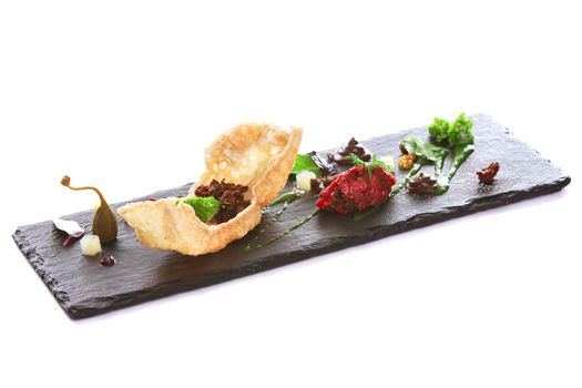 Molecular modern cuisine. Chips Pigskin with tartare or carpaccio of beef. Stock image. Isolated on white.