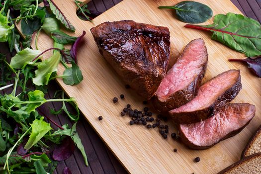 Close-up of Medium Rare Roast Beef with Fresh Herbs and Vegetables