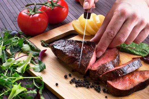 Close-up of Medium Rare Roast Beef with Fresh Herbs and Vegetables