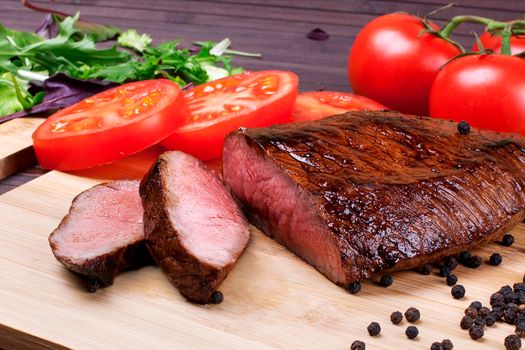 Close-up of Medium Rare Roast Beef with Fresh Herbs and Vegetables