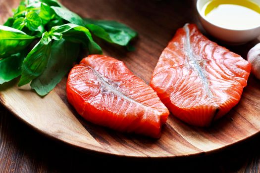 Raw humpback salmon steaks, rustic wooden background, above view. Fillet with fresh ingredients for tasty cooking and frying pan. Top view. Healthy and diet food concept.