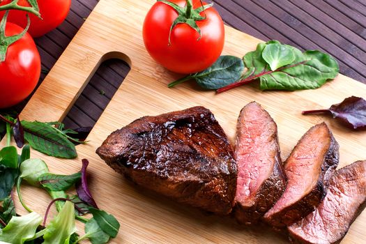 Close-up of Medium Rare Roast Beef with Fresh Herbs and Vegetables