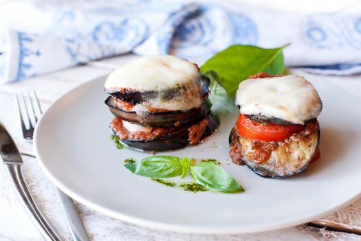 Parmigiana di melanzane: baked eggplant - italy, sicily cousine. On the wooden table.