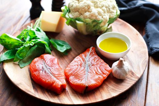 Raw humpback salmon steaks, rustic wooden background, above view. Fillet with fresh ingredients for tasty cooking and frying pan. Top view. Healthy and diet food concept.