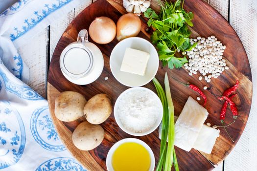 Wooden plate with ingredients from fish and vegetables for cooking cutlets with mashed potatoes