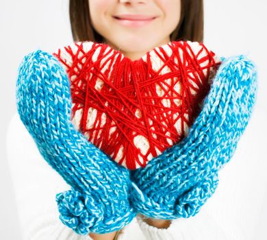 Girl hands in blue knitted mittens holding romantic red heart. With love. St. Valentine concept. Isolated.