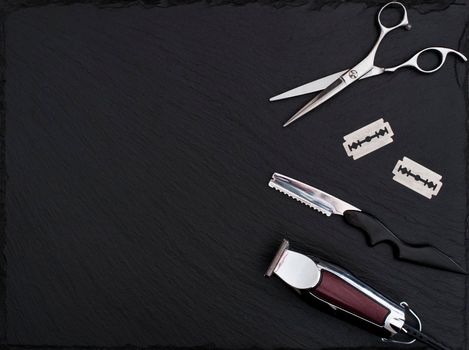 Barber shop equipment on Black background with place for text. Professional hairdressing tools. Comb, scissor, clippers and hair trimmer isolated.