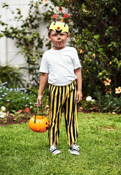 Full length portrait of an adorable little boy standing outside in his Halloween costume.