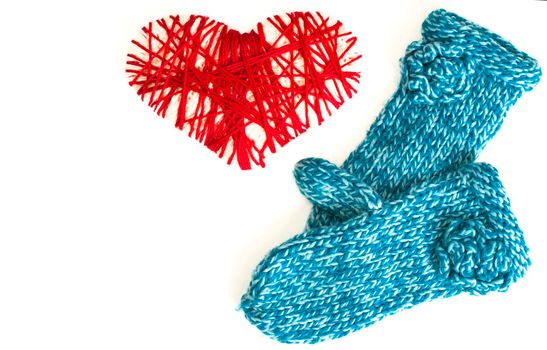 Woman's or girl's blue mittens and woven red heart valentine card on a isolated white background