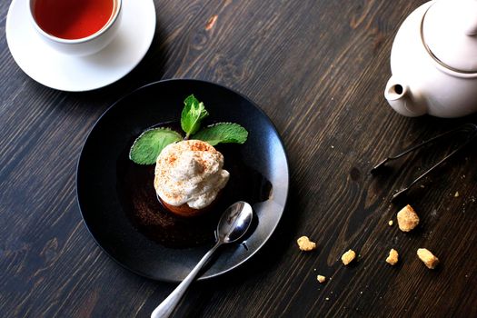 Breakfast time . Tea and cake with cream, garnished with mint leaves