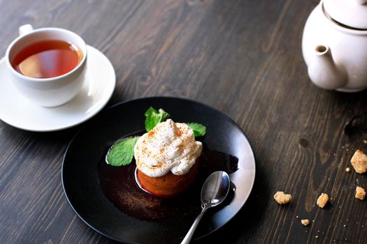 Breakfast time . Tea and cake with cream, garnished with mint leaves