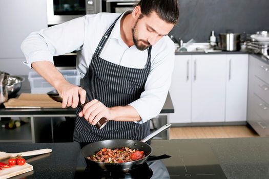 Chef preparing dishes in a frying pan
