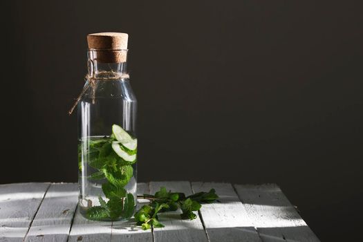 Nutritious detox water or emonade with cucumber and mint on wooden table