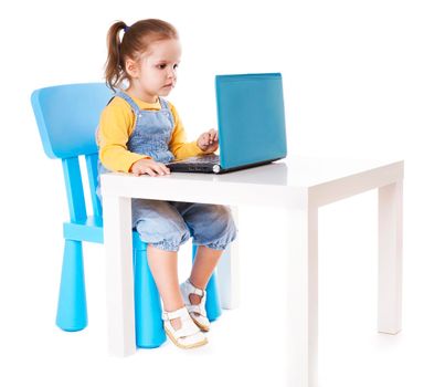 Portrait of a cute little girl using laptop. Horizontal shot. Isolated on white.
