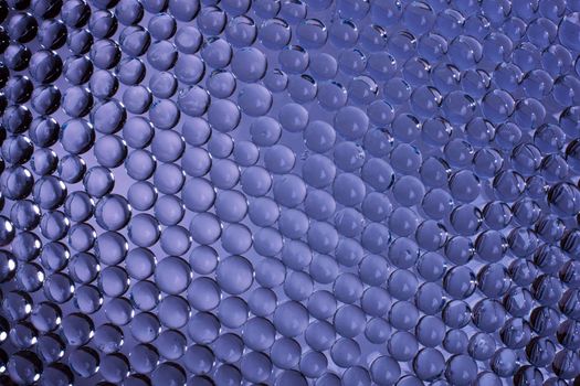 Background of glass beads in blue with highlights. Stock image.