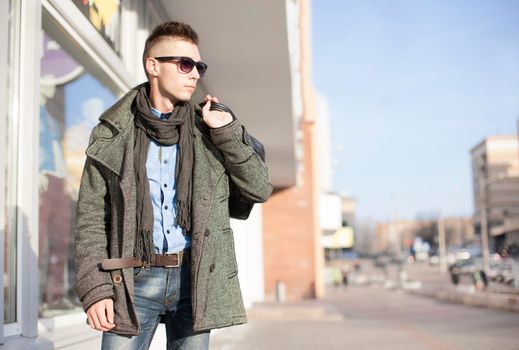 Young sexy man with bags doing shopping at the city center