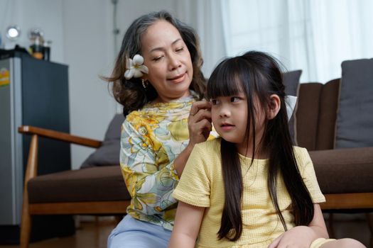 Asian portrait, grandma and granddaughter doing leisure activities and hugging to show their love and care for each other.