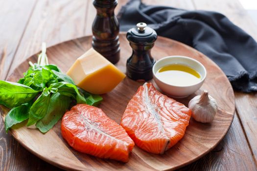 Raw humpback salmon steaks, rustic wooden background, above view. Fillet with fresh ingredients for tasty cooking and frying pan. Top view. Healthy and diet food concept.
