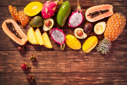 Tropical fruits, papaya, Dragon Fruit, rambutan, tamarind, avocado, granadilla, carambola kumquat mango mangosteen passionfruit On a wooden background. Assorted