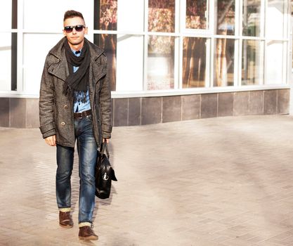 Young sexy man with bags doing shopping at the city center