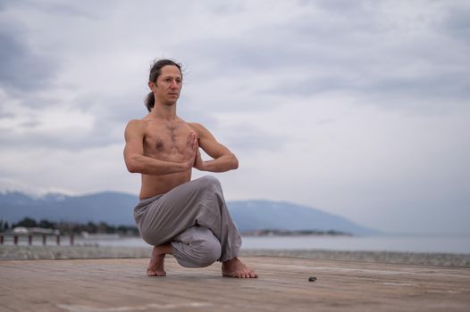 Caucasian man practices martial arts outdoors. balance and meditation