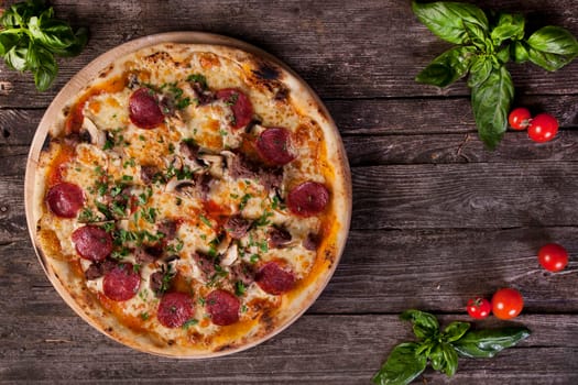 Pepperoni Pizza with salami, mushrooms , meat , beef, cheese and green onions on the wooden background. Top view.