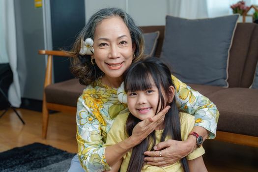 Asian portrait, grandma and granddaughter doing leisure activities and hugging to show their love and care for each other.