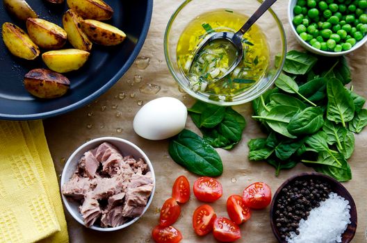 Fresh vegetables and ingredients for cooking tuna salad on the wooden. Dark colors.