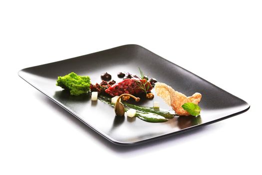 Molecular modern cuisine. Chips Pigskin with tartare or carpaccio of beef. Stock image. Isolated on white.