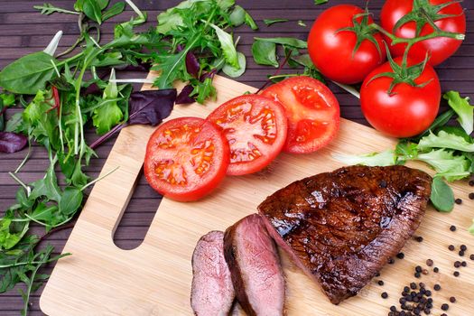 Close-up of Medium Rare Roast Beef with Fresh Herbs and Vegetables