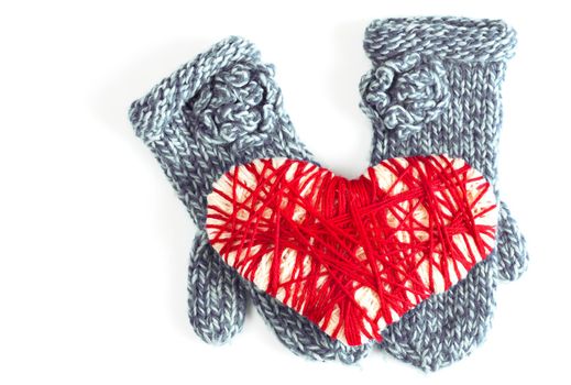 Woman's or girl's blue mittens and woven red heart valentine card on a isolated white background