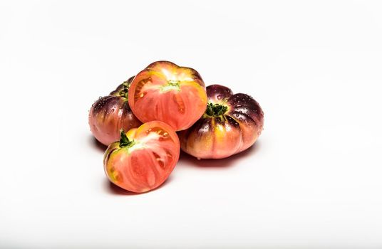 Several tomatoes of the tiger variety on a white background