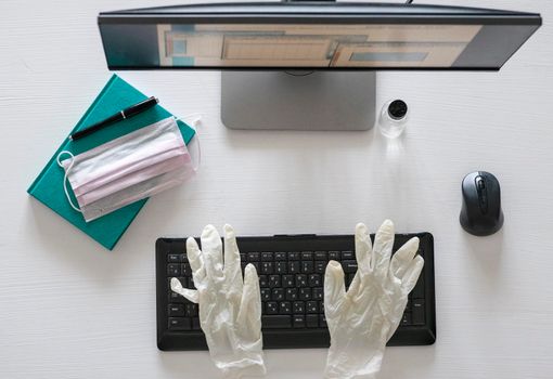 Flat lay, Top view work form home and COVID-19 prevention concept on wooden office table desk, Laptop computer with clean gel and mask, Medical gloves and supplies with copy space