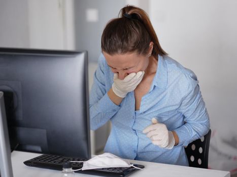 Ill young woman using laptop wearing face mask and coughing, sneeze, working from home or at office