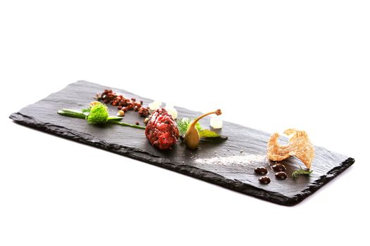 Molecular modern cuisine. Chips Pigskin with tartare or carpaccio of beef. Stock image. Isolated on white.