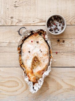 Grilled salmon steak with spices on wooden background. Top view