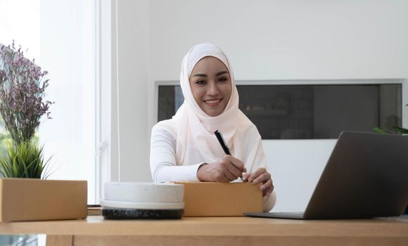 Muslim business woman working in office, Modern Muslim Business Woman, SME, Small business, Online trading and shipping services..