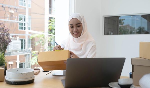 Muslim business woman working in office, Modern Muslim Business Woman, SME, Small business, Online trading and shipping services..