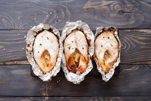 Grilled salmon steak with spices on wooden background. Top view