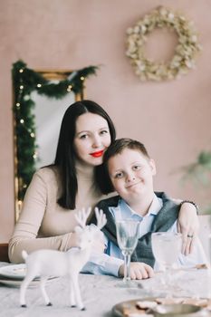 Happy family at home. Son with mom enjoying time together in a cozy room. Motherhood concept.