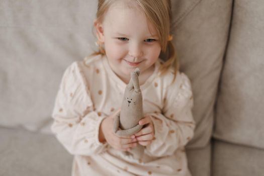 Little girl holding a toy at home. Happy child