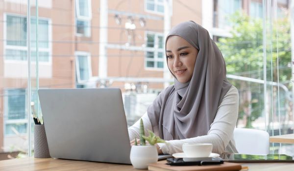 Asian Muslim business woman in hijab headscarf working with computer laptop in the modern office. business people, diversity and office concept.