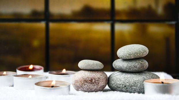 Zen concept, spa pebbles stones and burning aroma candles on blurred background, Treatment aromatherapy and massage, copy space for text