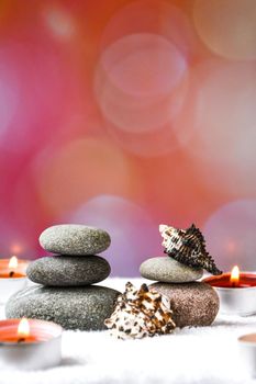 Zen concept, spa pebbles stones and burning aroma candles sea shells on blurred background, Treatment aromatherapy and massage, copy space for text