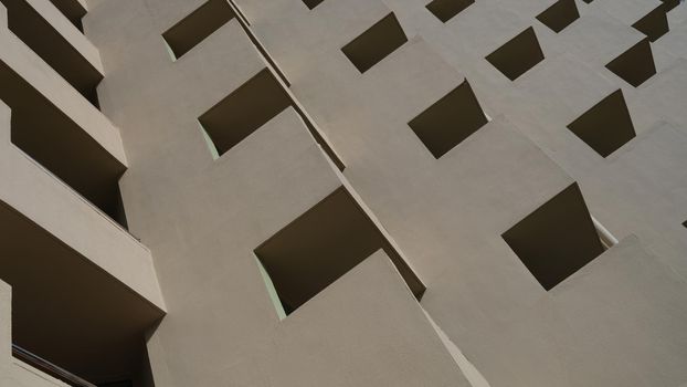 Facade of brown building with square patterns closeup background. Building design and architecture concept